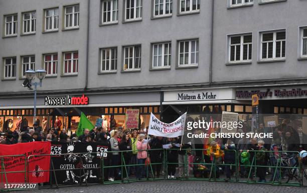 Demonstrators hold up a banner reading "Who votes for Hoecke votes for fascism" as they protest against the top candidate of the far-right...