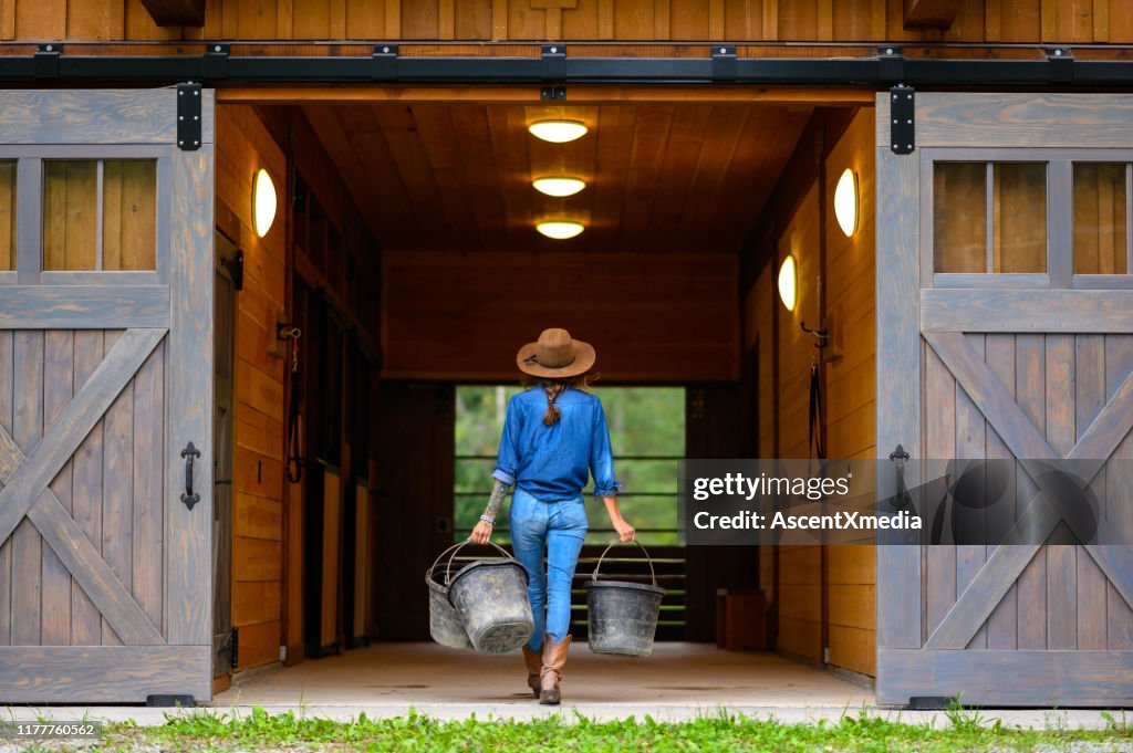 Fermier féminin fort travaillant sur son ranch