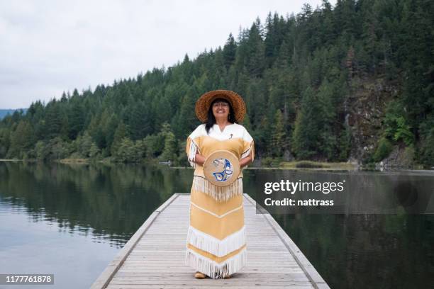 a senior indigenous canadian woman stands with her musical instrument - canadian culture stock pictures, royalty-free photos & images