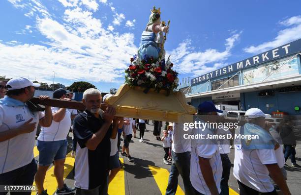 Local fishermen in procession with a replica statue of the Santa Maria Di Porto Salvo during the blessing of the fleet celebrations at Sydney Fish...