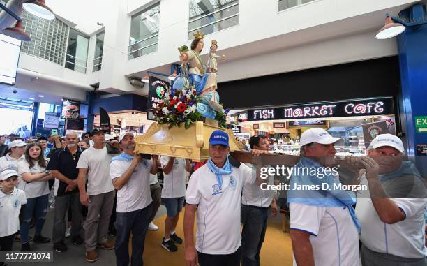 Local fishermen in procession with a replica statue of the Santa Maria Di Porto Salvo during the blessing of the fleet celebrations at Sydney Fish...