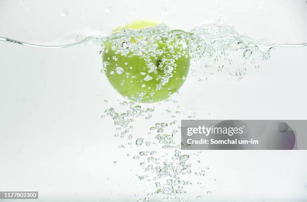 green apple in the water splash - apple water splashing stock pictures, royalty-free photos & images