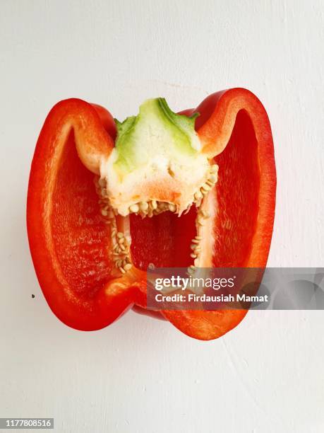 freshly half cut capsicum against white background - red pepper stock pictures, royalty-free photos & images