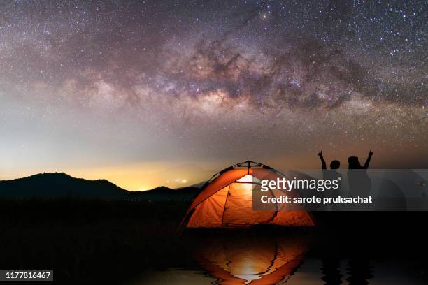 two asian girls outdoor camping outdoor on holiday  majestic milky way . vacation ,camping ,travel and relaxing concepts. - day for night 2017 fotografías e imágenes de stock