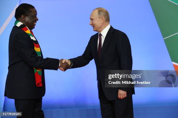 Russian President Vladimir Putin greets Zimbabwean President Emmerson Mgangagwa during the welcoming ceremony at the Russia-Africa Summit in Black...