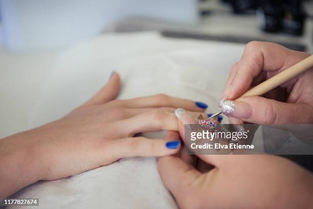 teenager having her nails painted by a professional beautician - nagelkunst stockfoto's en -beelden