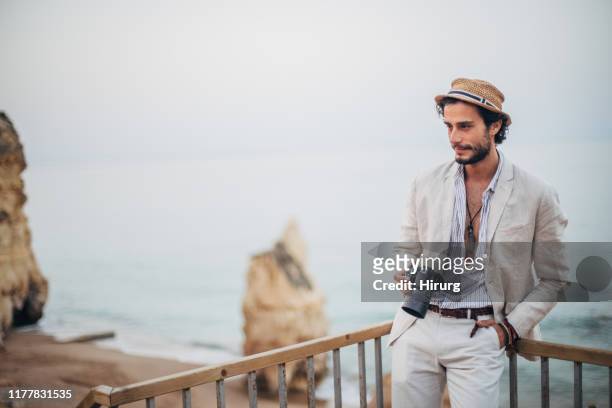 fashionable photographer on the beach - hunky guy on beach stock pictures, royalty-free photos & images