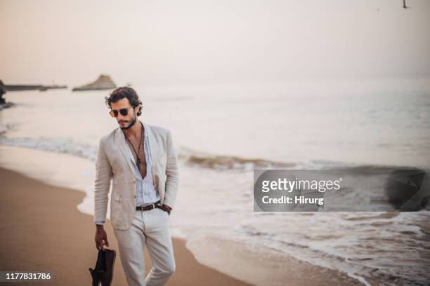 ��在沙灘上散步的現代人 - white blazer 個照片及圖片檔