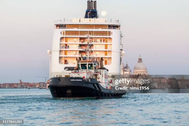 cruiseschip in venetië in st. mark's basis in de buurt van st. george island - pericolo stockfoto's en -beelden