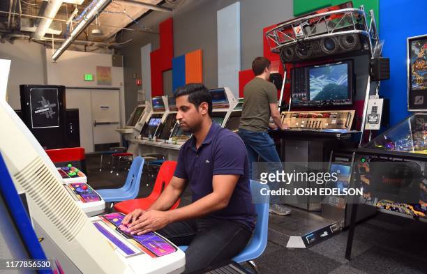 Facebook employees play video games inside an arcade at the company's corporate headquarters campus in Menlo Park, California, on October 23, 2019.