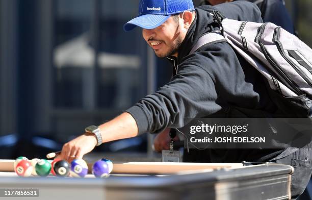 Facebook employee plays pool at the company's corporate headquarters campus in Menlo Park, California, on October 23, 2019.