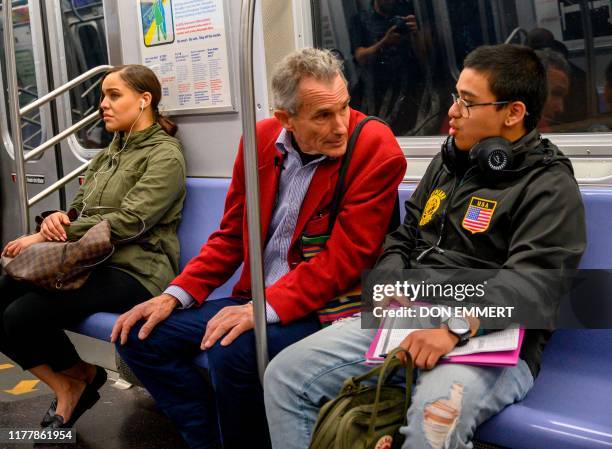 Richard McLachlan , a member of Extinction Rebellion, the environmental action pressure group founded in Britain, speaks with subway rider Anthony...