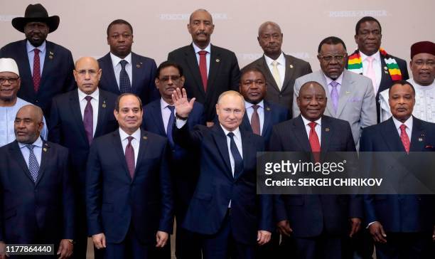 Russian President Vladimir Putin gestures as Egypt's President Abdel Fattah al-Sisi and South African President Cyril Ramaphosa pose for a family...