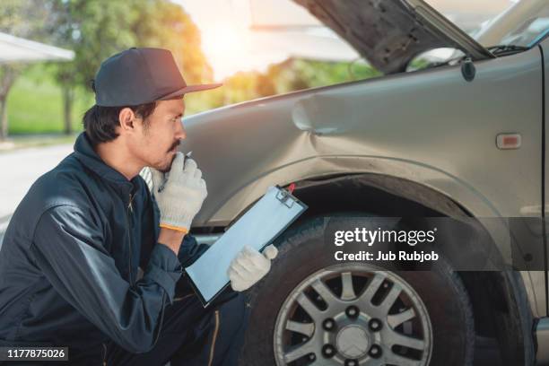 mechanic inspecting damaged vehicle - auto repair shop stockfoto's en -beelden