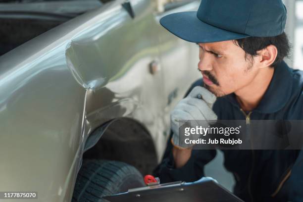 mechanics checking damaged automobile - abollado fotografías e imágenes de stock
