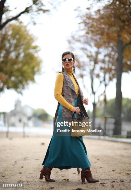 Füsun Lindner wearing a vest and skirt by Nobi Talai, bag from by Far, Paris Texas boots and a Prada sunglasse on September 27, 2019 in Paris, France.