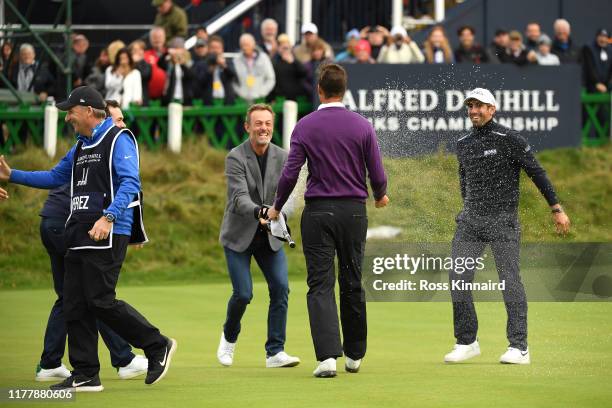 Victor Perez of France is sprayed with a bottle of champagne by Raphael Jacquelin following his victory on the 18th hole during Day four of the...