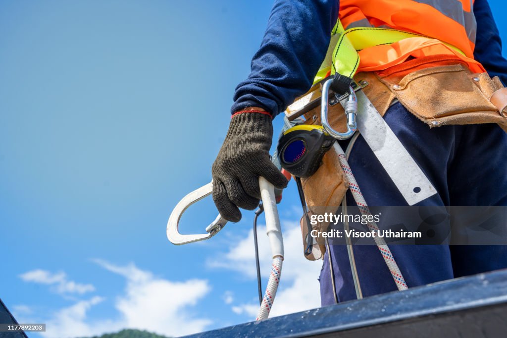 Construction worker wearing safety harness and safety line