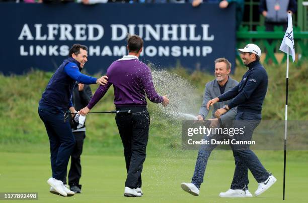 Victor Perez of France is sprayed with champagne by Raphael Jacquelin of France on the 18th hole after he had holed the winning putt during the final...