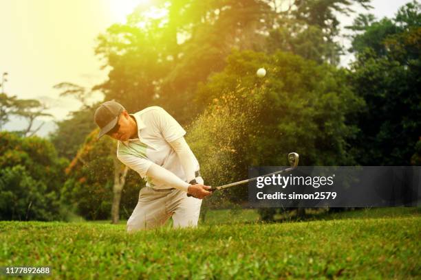 golfer chipping out of sand trap - swinging golf club stock pictures, royalty-free photos & images