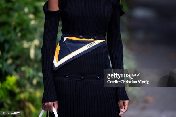 Guest is seen wearing black pleated pants, Loewe scarf outside Issey Miyake during Paris Fashion Week Womenswear Spring Summer 2020 on September 27,...