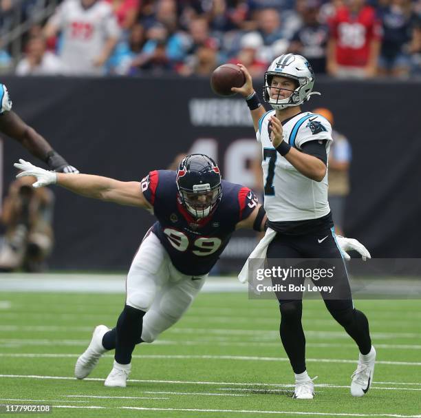 Kyle Allen of the Carolina Panthers scrambles out of the pocket pressured by J.J. Watt of the Houston Texans during the first half at NRG Stadium on...