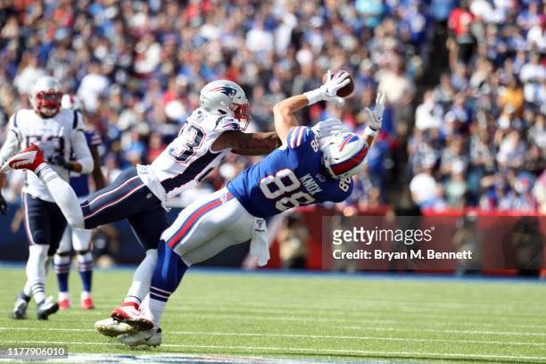 Dawson Knox of the Buffalo Bills catches the ball as Patrick Chung of the New England Patriots attempts to break up the pass during the second...
