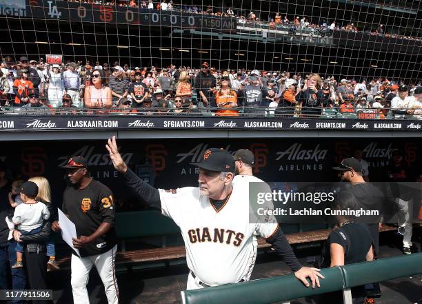 Manager Bruce Bochy of the San Francisco Giants acknowledges the fans as he walks into the dugout before his last game as Giants manager, the game...