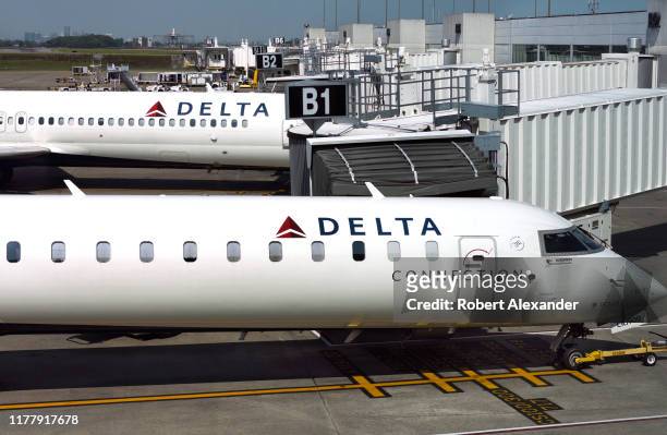 Delta Connection passenger jet parked at a gate beside a Delta Airlines plane at Nashville International Airport in Nashville, Tennessee.
