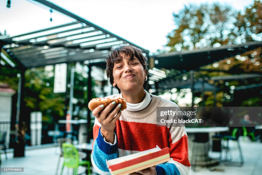 Junge Frau essen Hot Dog auf der Straße