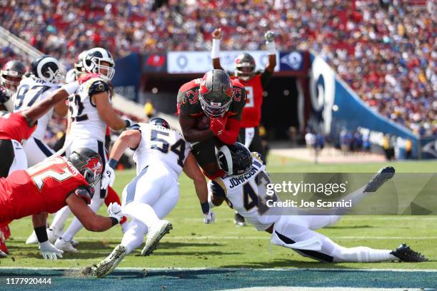 Peyton Barber of the Tampa Bay Buccaneers jumps for a touchdown in the first quarter as John Johnson of the Los Angeles Rams tackles him in the end...