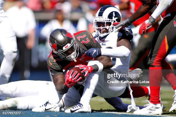 Running back Ronald Jones of the Tampa Bay Buccaneers scores a touchdown as he's tackled by defensive back Nickell Robey-Coleman and strong safety...