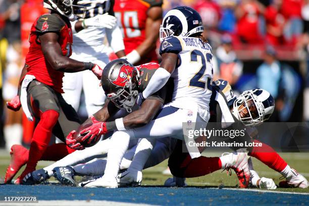 Running back Ronald Jones of the Tampa Bay Buccaneers scores a touchdown as he's tackled by defensive back Nickell Robey-Coleman and strong safety...
