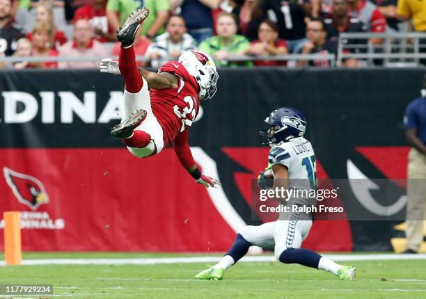 Wide receiver Tyler Lockett of the Seattle Seahawks catches a pass behind a leaping Budda Baker of the Arizona Cardinals during the first half of the...