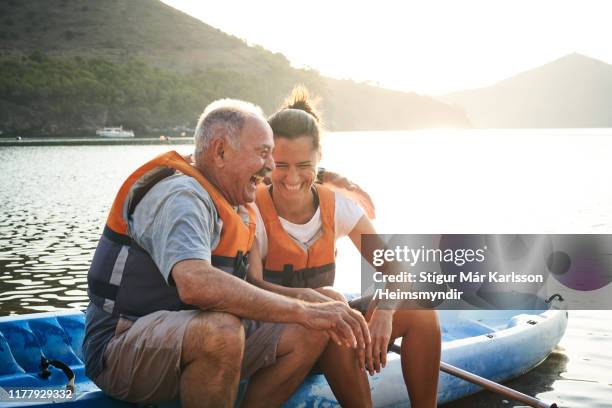 man en dochter met arm rond zittend op kajak - father and grown up daughter stockfoto's en -beelden