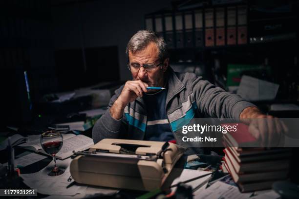 an older journalist works at night - journalist desk stock pictures, royalty-free photos & images