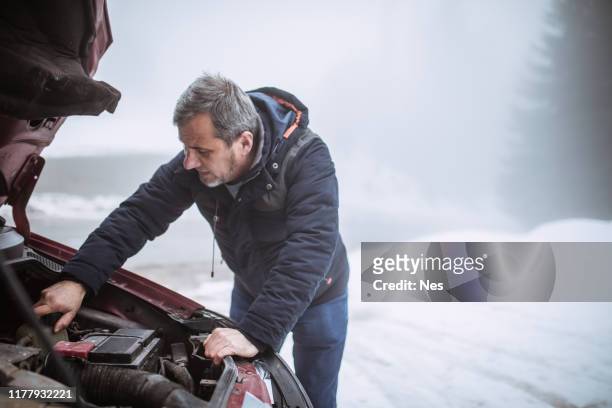 ein älterer mann hat eine autopanne, winterwetter - winter panne auto stock-fotos und bilder