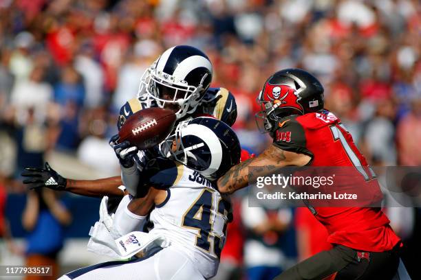 Free safety Eric Weddle and strong safety John Johnson of the Los Angeles Rams break up a pass intended for wide receiver Mike Evans of the Tampa Bay...