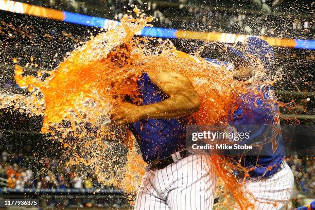 Dominic Smith of the New York Mets has gatorade dumped on him after hitting a walk-off 3-run home run in the bottom of the eleventh inning against...