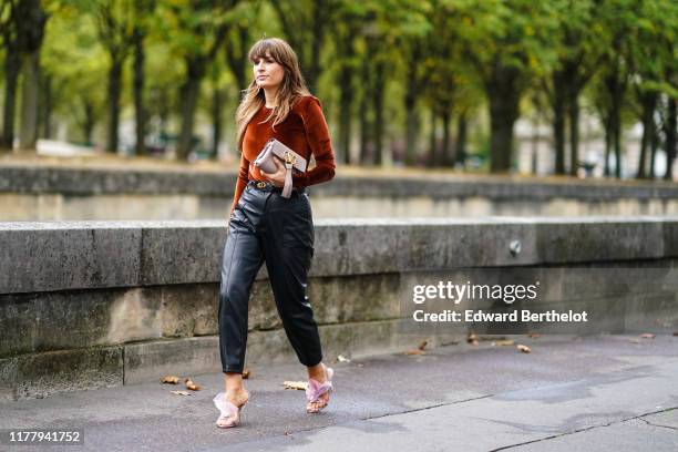 Carlotta Rubaltelli wears a brown lustrous velvet top, a Valentino bag, black leather pants, pink sandals, outside Valentino, during Paris Fashion...