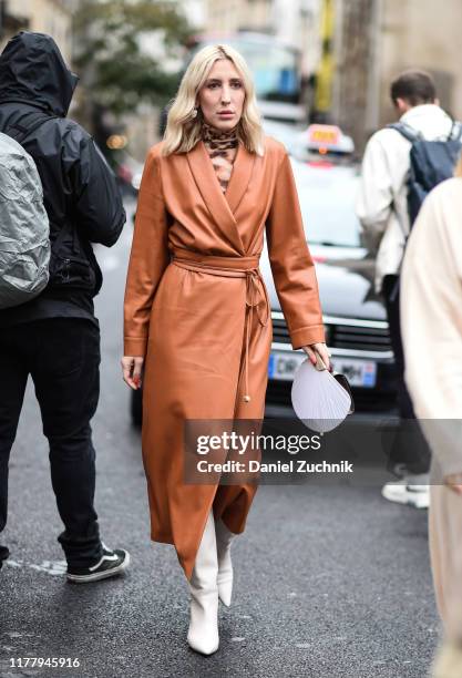 Guest is seen wearing a Thom Browne leather brown coat outside the Thom Browne show during Paris Fashion Week SS20 on September 29, 2019 in Paris,...