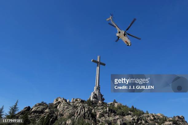 Spanish army Super Puma helicopter carrying the remains of Spanish dictator Francisco Franco leaves the Valle de los Caidos mausoleum in San Lorenzo...