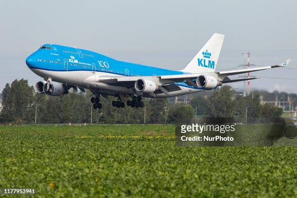 Royal Dutch Airlines Boeing Jumbo Jet 747-400M airplane as seen on final approach landing, touch down and rubber smoke at Polderbaan runway 18R/36L...