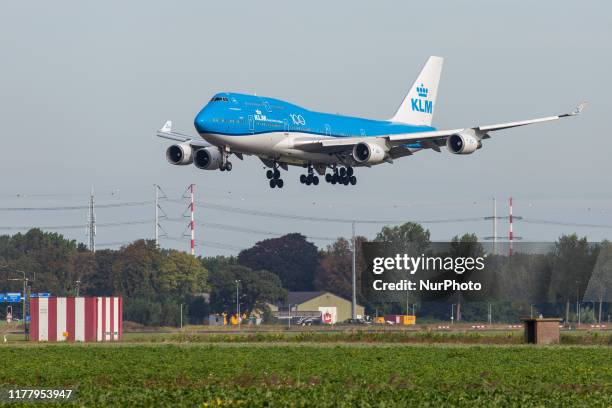 Royal Dutch Airlines Boeing Jumbo Jet 747-400M airplane as seen on final approach landing, touch down and rubber smoke at Polderbaan runway 18R/36L...