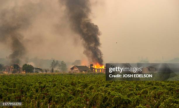 Building is engulfed in flames at a vineyard during the Kincade fire near Geyserville, California on October 24, 2019. Fast-moving wildfire roared...