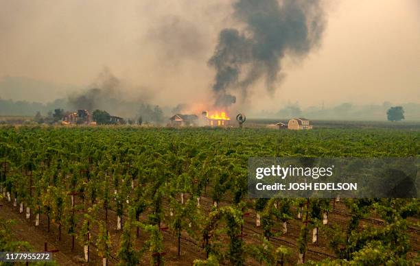 Building is engulfed in flames at a vineyard during the Kincade fire near Geyserville, California on October 24, 2019. Fast-moving wildfire roared...