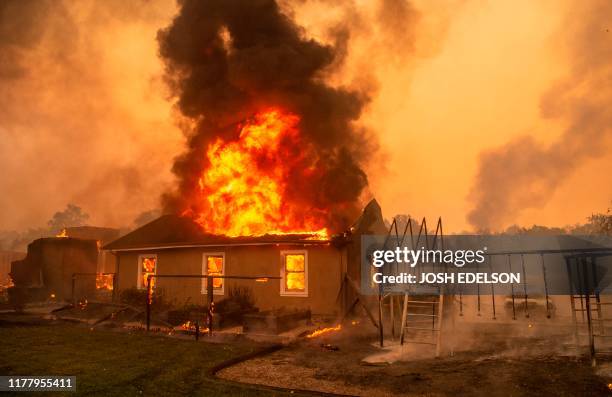 Home burns at a vineyard during the Kincade fire near Geyserville, California on October 24, 2019. - fast-moving wildfire roared through California...