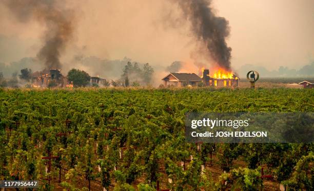 Building is engulfed in flames at a vineyard during the Kincade fire near Geyserville, California on October 24, 2019. - fast-moving wildfire roared...