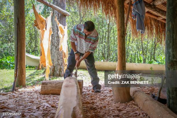 Daniel Tommie, of the Seminole Tribe's Bird Clan, carves a canoe at the traditional Hunting Camp at the Ah-Tah-Thi-Ki Museum on the Big Cypress...