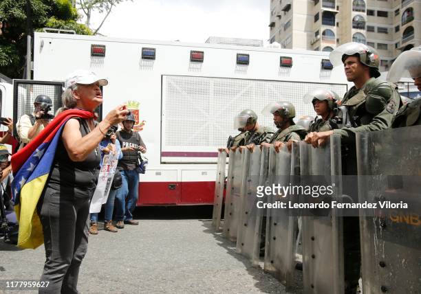 Opposition supporter shouts to National Guard members behind a barricade during a protest due to power, water and communication services faults in...